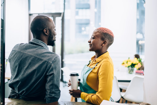 Black baristas flirting during break in cafe