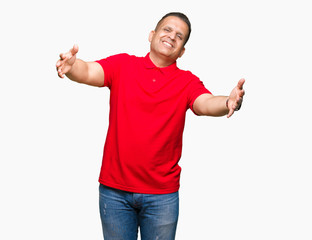 Fototapeta premium Middle age arab man over isolated background looking at the camera smiling with open arms for hug. Cheerful expression embracing happiness.