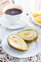 Baked quail egg avocado for breakfast on a white plate, selective focus