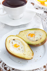 Baked quail egg avocado for breakfast on a white plate, selective focus