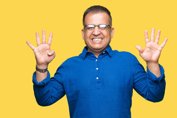 Fototapeta premium Middle age arab man wearing glasses over isolated background showing and pointing up with fingers number nine while smiling confident and happy.