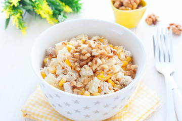 Salad with corn, chicken and pineapples in a white bowl, horizontal