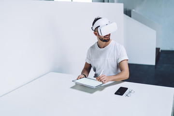 Cheerful male digitizer testing reality online game with high technology - VR headset and blank...