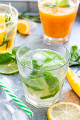 Mojito on the background of summer cold drinks with citrus fruits: lemonade, oranzhad, grape juice and mandarin juice, selective focus