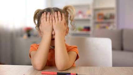 Little girl closing eyes with hands, waiting for surprise, birthday celebration