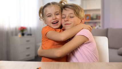 Happy boy and girl hugging, brother sister closeness, tender family relations