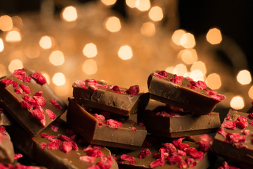 Close-up of chocolate with cinnamon sticks, anise and coffee on a rustic background. Festive garlands.