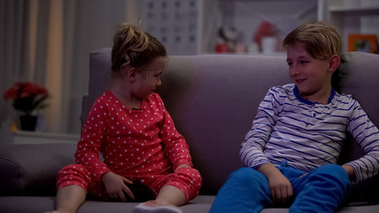 Little boy winning video game round, sister getting upset, play competition