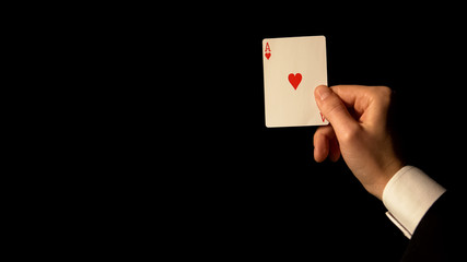 Hand showing ace card on black background, concept of luck in gambling, casino