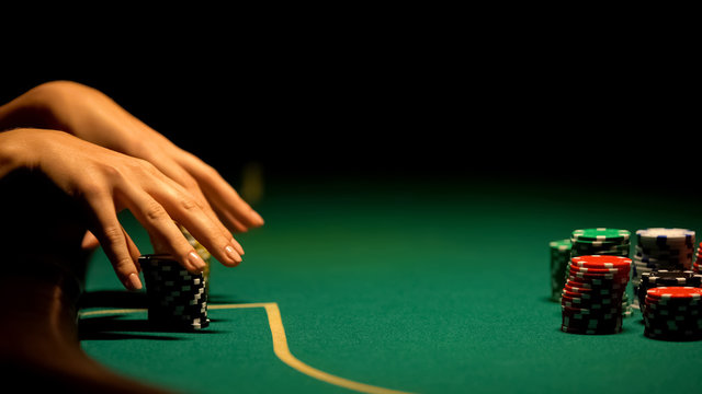 Female hands taking casino chips, strategy and betting all-in, bluffing, closeup