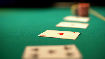 Cards lying on green table, ace of hearts, poker and blackjack casino games