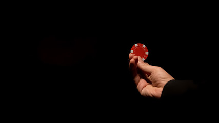 Man holding casino chip, inviting gambler for game, isolated on black background