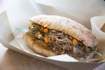 beef in japonet bun with green leave and pieces of carrot. close up shot selective focus.