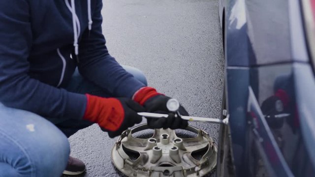 Male hands with wrench. Man changing flat tire on his car after road accident