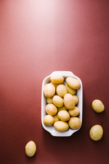 Small rounded potatoes ready  to be cooked in oven, top view on a brown,flatlay background