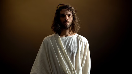 Jesus in crown of thorns looking to camera, punishment for mortal people sins