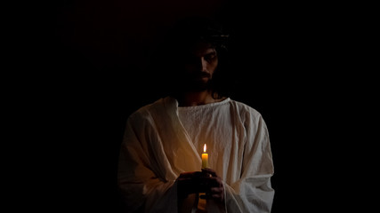 God son in thorns crown holding candle, holy martyr praying for people, kindness