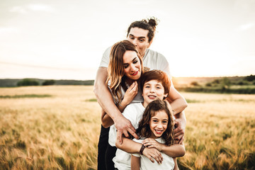 Naklejka na ściany i meble Portrait of a happy and fun family in the countryside. Concept of love family