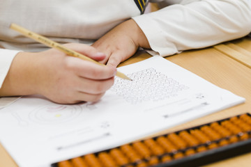 Crop kid fulfilling exercises during lesson