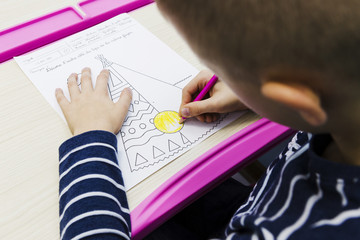 Unrecognizable boy coloring picture