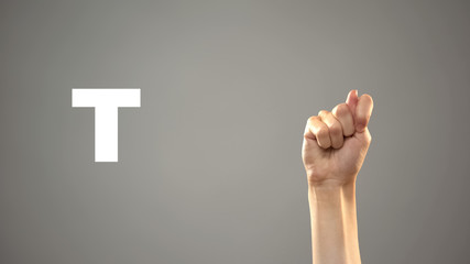 Letter T in sign language, hand on background, communication for deaf, lesson