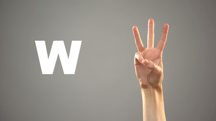 Letter W in sign language, hand on background, communication for deaf, lesson