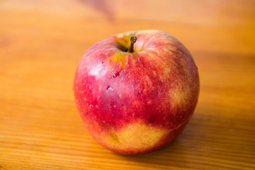 red apple on a wooden gray board, drops of water on the apple, texture, background, close-up, fruit