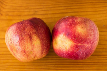 two red apples on a wooden brown board, drops of water on an apple, texture, background, close-up, fruit