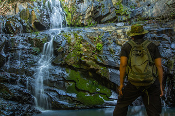 Men love to travel and hiking Adventure photographed young Thai people in Asia. Take yourself while walking on the Ton Aow Yon Waterfall ,in the forest tropical zone,national park Phuket Thailand.