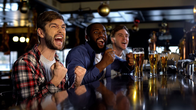 Excited multiethnic friends supporting sports team, victory of national team