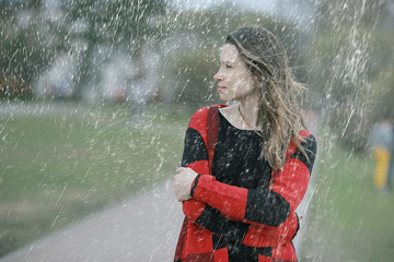 rainy weather girl posing fall / raindrops, spray, girl adult on a rain background