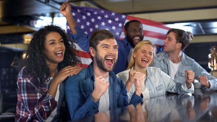 Excited sport fans with American flag celebrating victory of national team