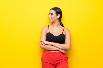 Young woman over isolated yellow background happy and smiling