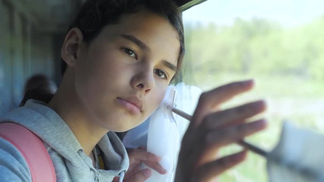 sad girl looks out the train window. travel transportation railroad concept. teen girl misses traveling in train compartment looking out the window. long train lifestyle journey by rail