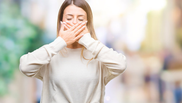 Young beautiful woman casual white sweater over isolated background shocked covering mouth with hands for mistake. Secret concept.
