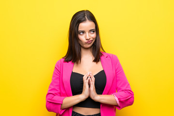 Young woman over isolated yellow background scheming something