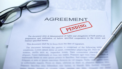 Agreement pending, seal stamped on official document, business contract closeup