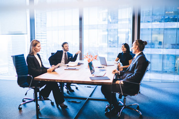 Multicultural professional experts dressed in elegant wear discussing productive plan for work of...