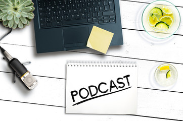 podcast recording concept, top view of laptop computer and microphone on rustic wooden table