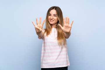 Young woman over isolated blue background counting nine with fingers