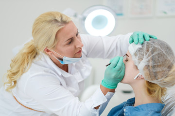 Beautician performing henna brows correction