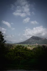 Mountain landscape looking on small villages, clouds cast shadows, warm summer day © Frederik Sowicki
