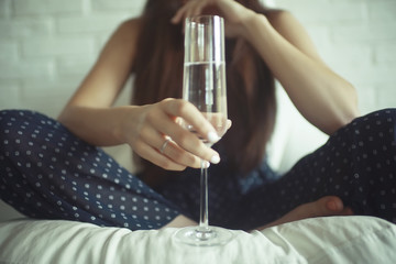 Girl with a glass of champagne at home