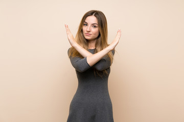 Young woman over isolated background making NO gesture