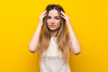 Obraz premium Young woman over isolated yellow wall unhappy and frustrated with something. Negative facial expression