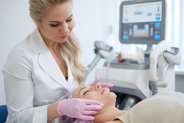 Woman getting treatment with aesthetic dermatology device - 275646774