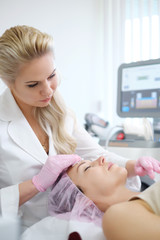 Obraz na płótnie Canvas Woman getting treatment with aesthetic dermatology device