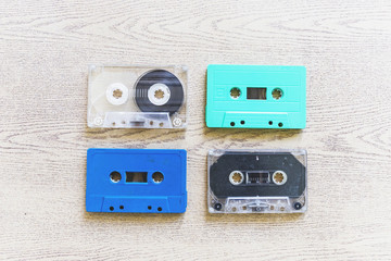 An overhead view of transparent; blue and turquoise colored cassettes on wooden background