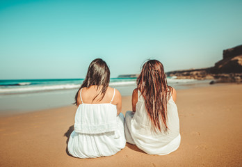 Chicas vestidas de blanco disfrutando en un bonito paisaje de la playa