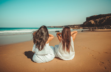 Chicas vestidas de blanco disfrutando en un bonito paisaje de la playa